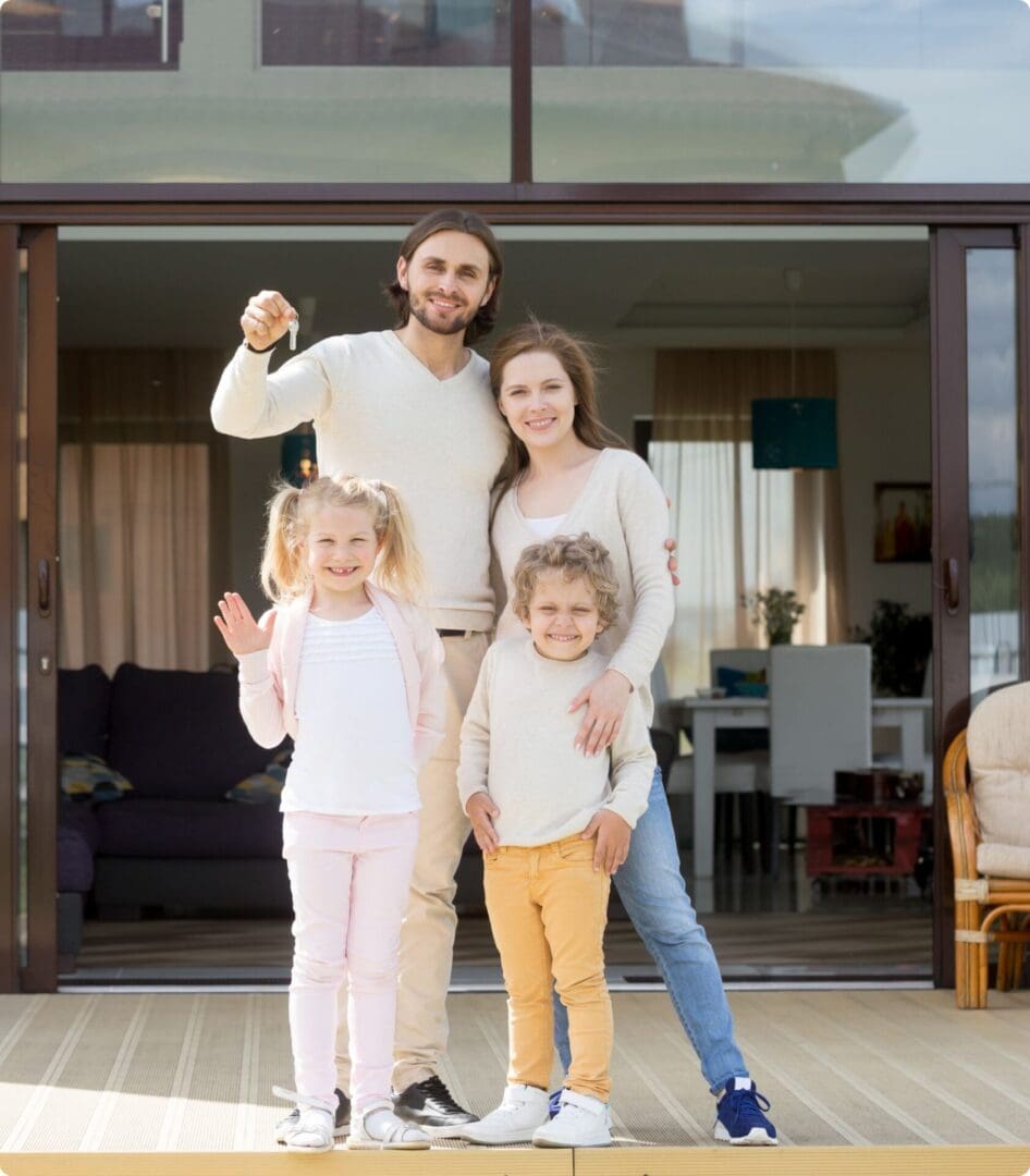 Family smiling together outside their home.